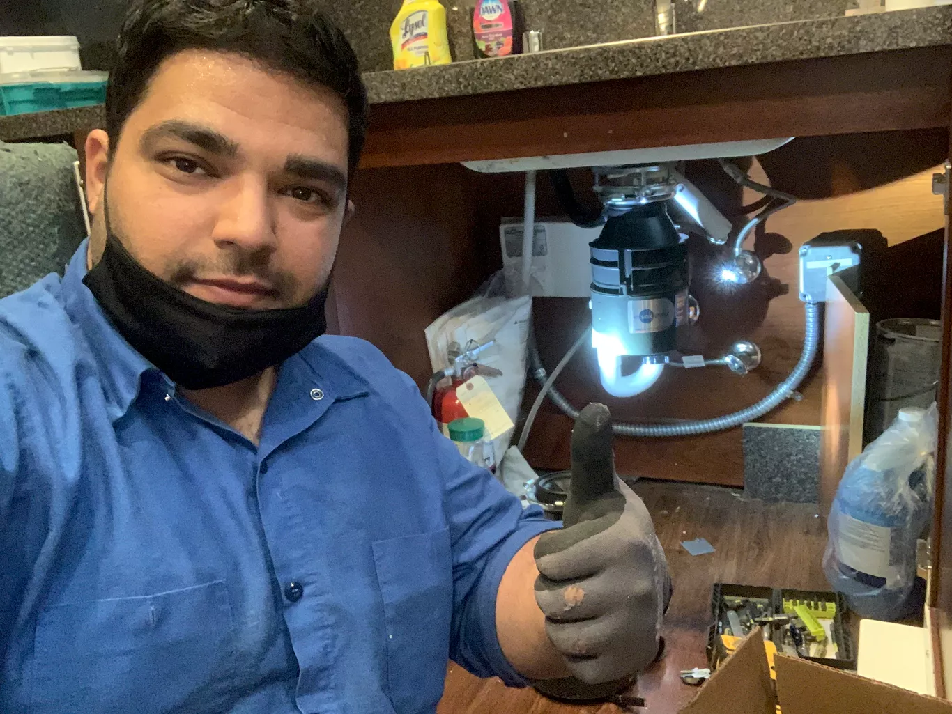 Ahmad M., owner of Safe Appliance Repair Service, servicing a garbage disposal